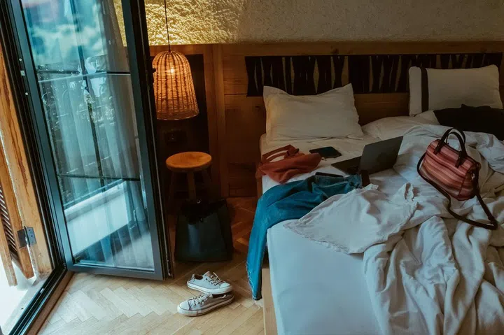 Mess in the room. Woman's clothing, computer on the bed
