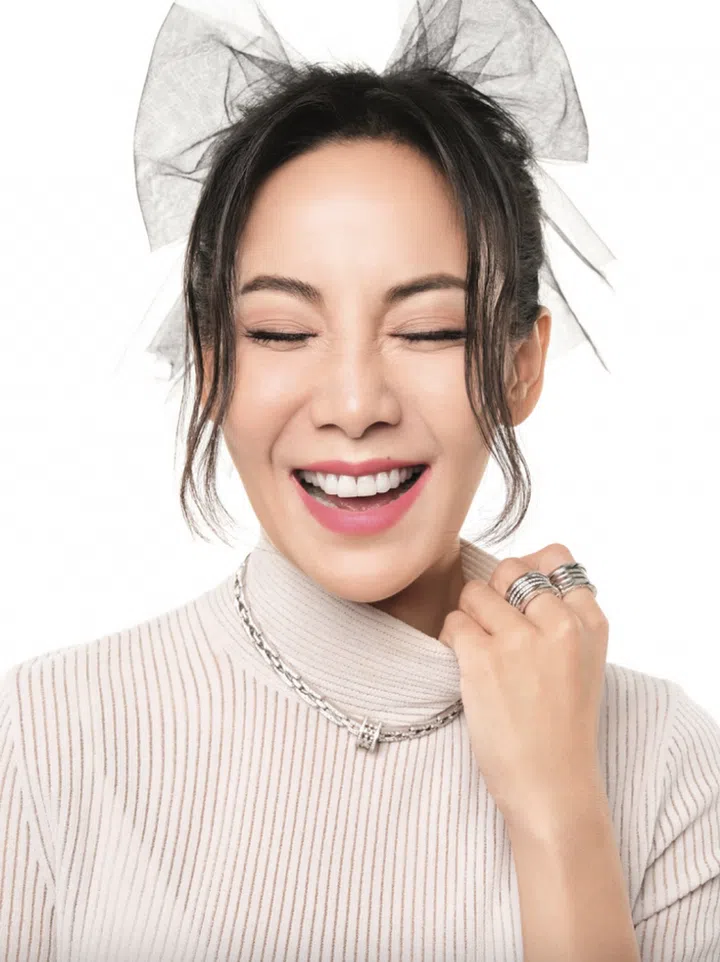 Sheer knit cropped tank top, Fendi. B.zero1 white gold pendant necklace with pave diamonds, B.zero1 5-band 20th Anniversary white gold ring, and B.zero1 5-band 20th Anniversary white gold ring with pave diamonds, Bvlgari. Tulle hair bow, stylist’s own