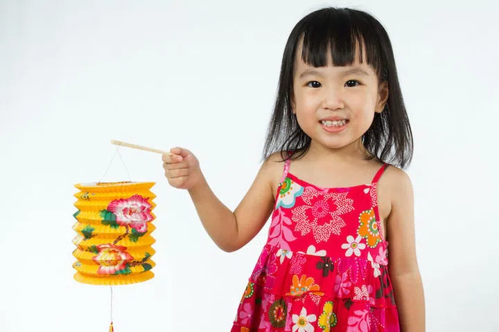 Chinese children holding latern celebrate mid-autumn festival (moon cake festival) in plain white isolated background.