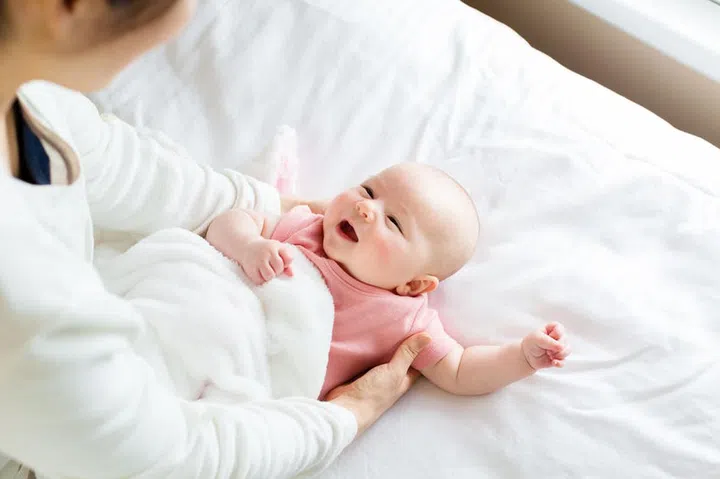 57133301 - newborn baby girl lying being cared for by her mother