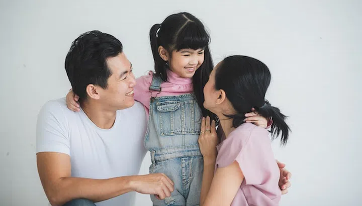 happy young Asian family with father mother and daughter living at home, spent time together