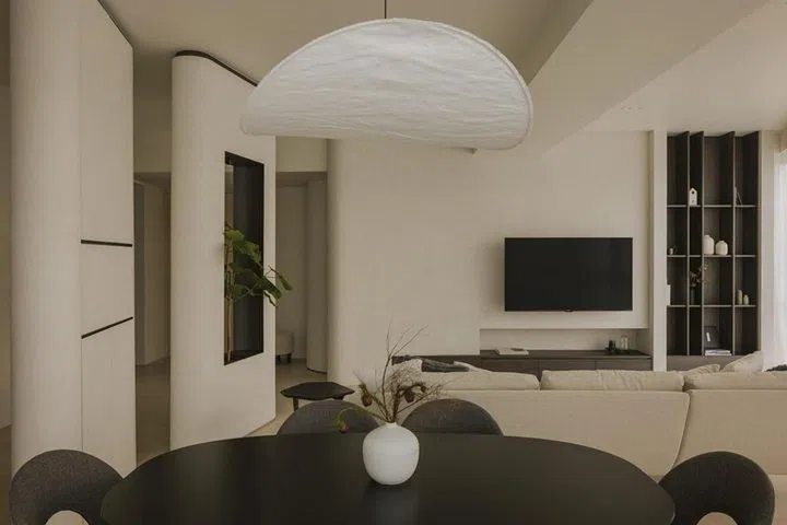 Dining table overlooks the living room and television in this all black and white private condominium apartment in Serangoon Gardens.Image Home & Decor