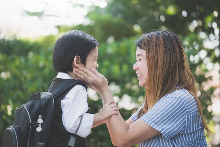 61510036 - asian mother  saying goodbye to her son as he leave for school,back to school concept