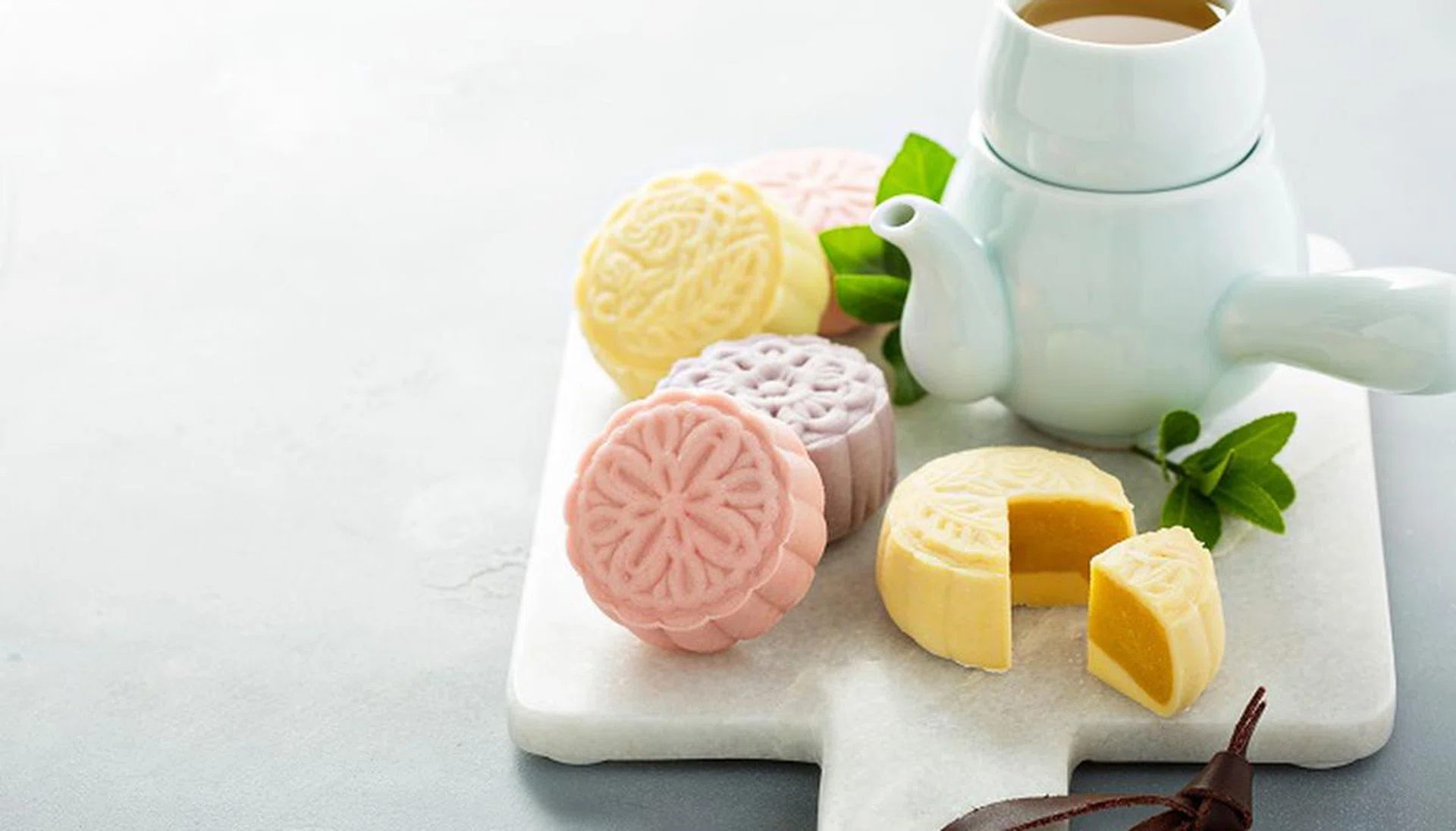 Snow skin sweet and savory traditional Chinese mooncakes with variety of fillings served with green tea