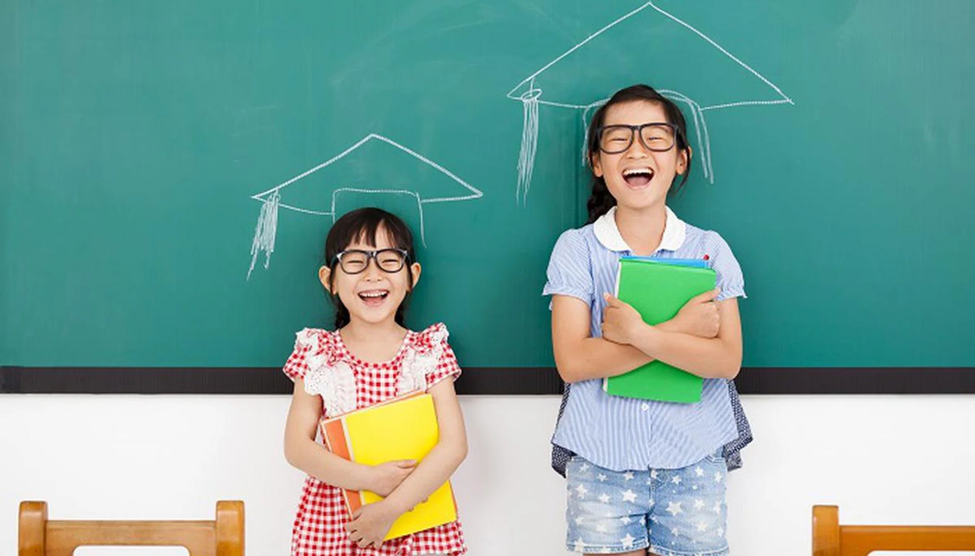 38126692 - happy little girls with graduation concept in classroom