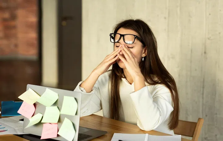 Difficult task at work concept. Girls eyes hurt, she removes glasses and rubs them