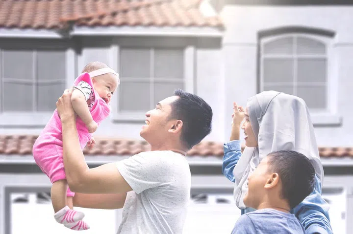 Two muslim parents playing with their baby and son at new house outside