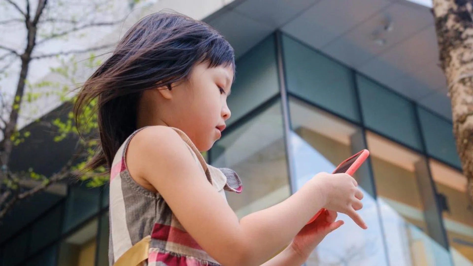 Asian child using cell phone in city