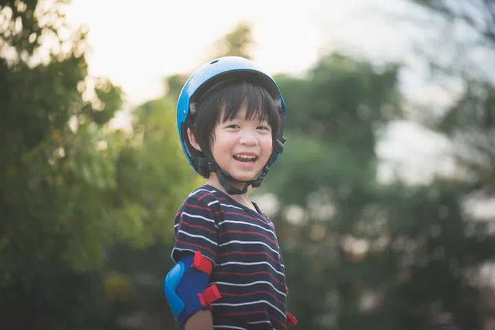 Portrait of happy Boy in blue helmet standing with nature background