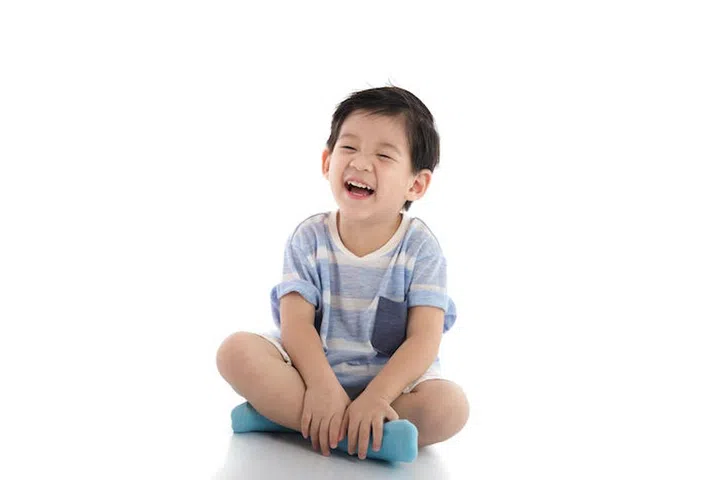 Happy asian boy sitting on white background isolated