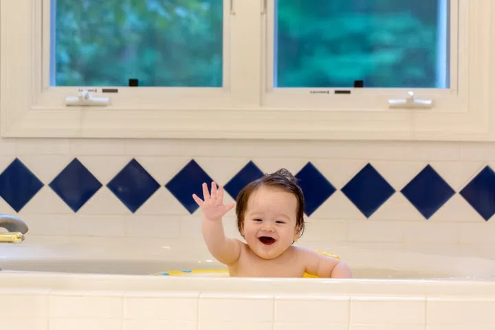 Baby boy taking a bath in a big bath tub