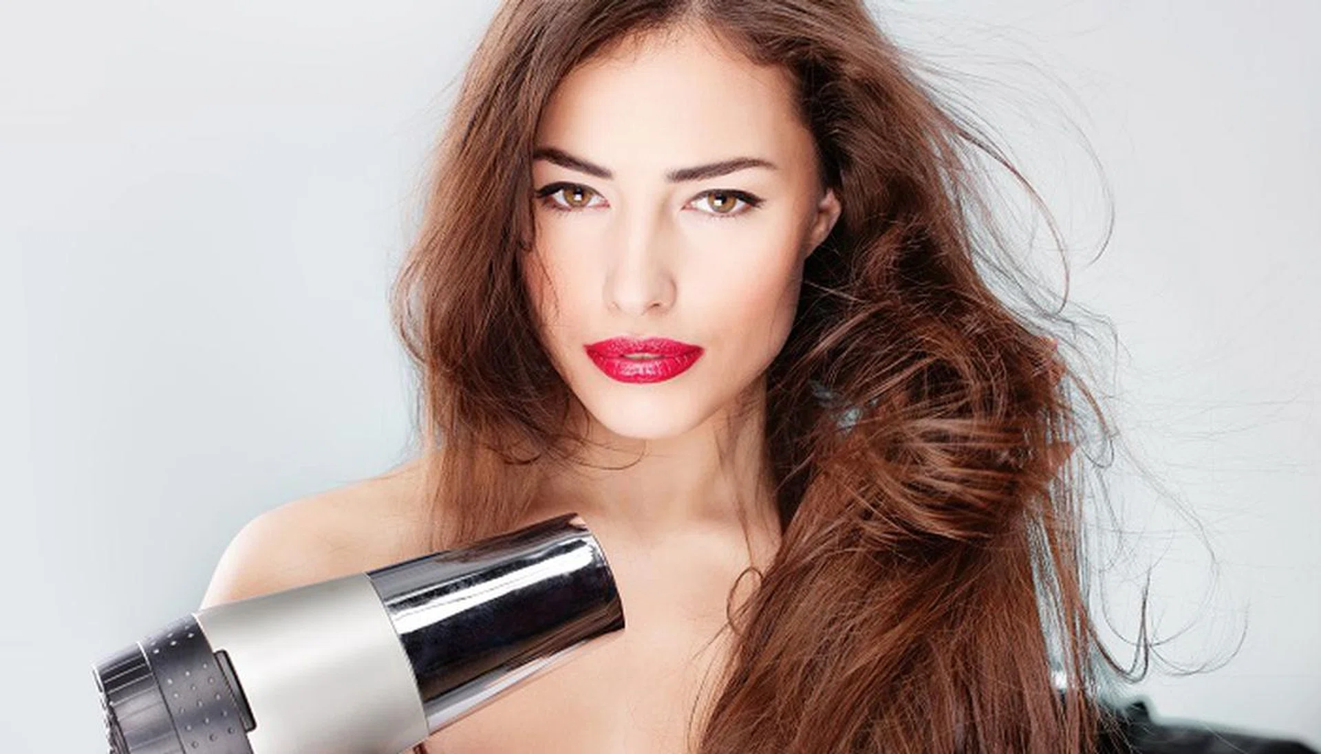 14743234 - woman with long hair holding blow dryer
