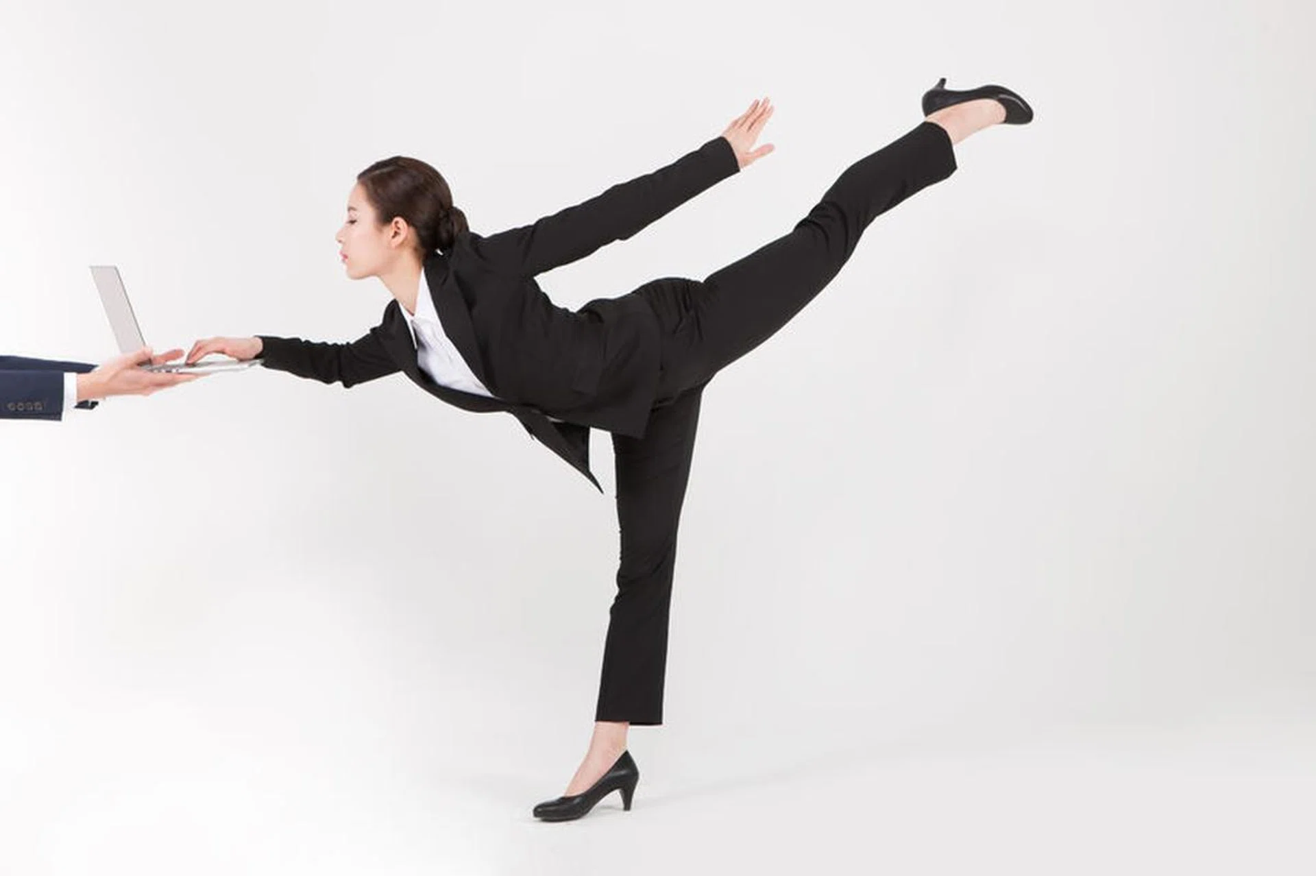 87071917 - asian business woman using laptop while doing ballet isolated on white