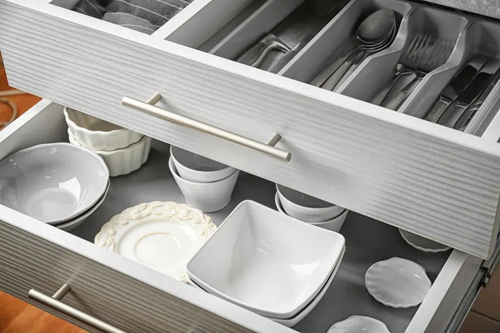 Ceramic dishware and cutlery in kitchen drawers
