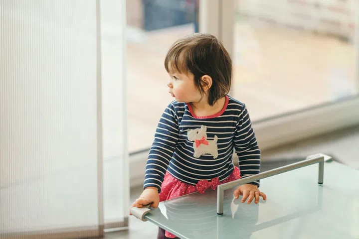 household safety of the children. girl standing at the table with the protection on the corners