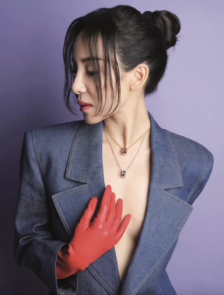 Denim oversized jacket and leather gloves, Saint Laurent. B.zero1 New Classic yellow gold necklace, and B.zero1 New Classic white gold necklace with demi pave, Bvlgari