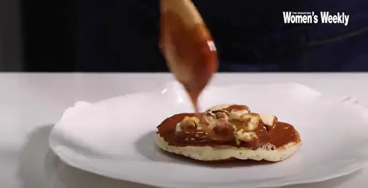 01. Start with one pancake as the base, top with generous servings of sliced bananas, walnuts, and drizzle over with peanut sauce.