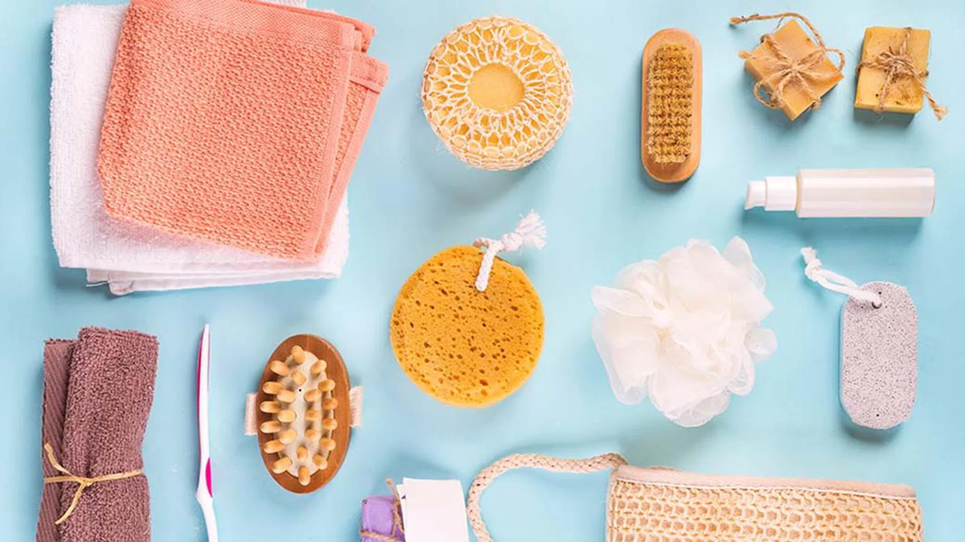 Flat lay bath products, cosmetic for shower. Scrub peeling brush body scrubber massager loofah bar of soap on blue. Top view photo natural cosmetics