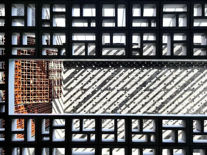 A deft use of textured bricks modulated with openings coupled with a striking pre-cast concrete screen helps to shield views of the house while providing visual interest.