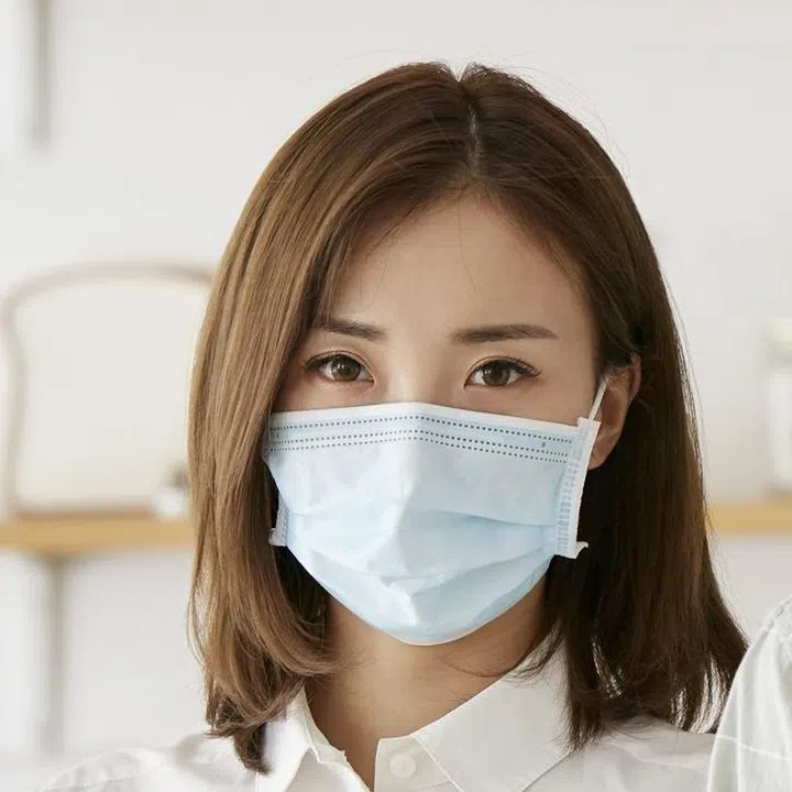 portrait of a young asian couple wearing mask looking at camera