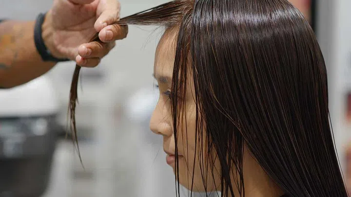 If you want a fringe, say "A fringe that sits just below my eyebrows and is rounder at the edges near my temples." (Photo by Envato)