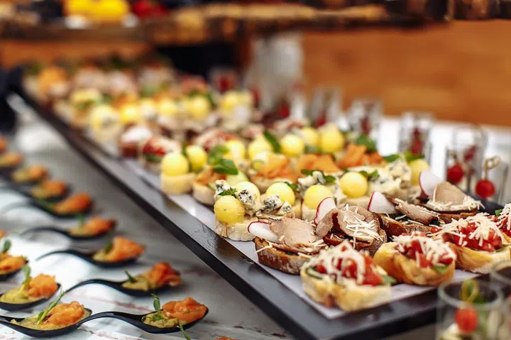 Different light snack on wooden tray on wedding party