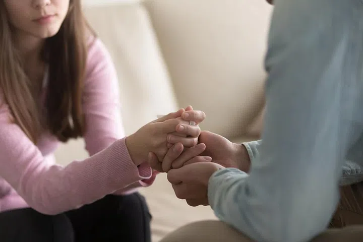 Close up view of upset couple, guy holding hands of crying woman, trying to comfort and console her, boyfriend apologizing offended lady, asking for forgiveness. Support, regret and compassion