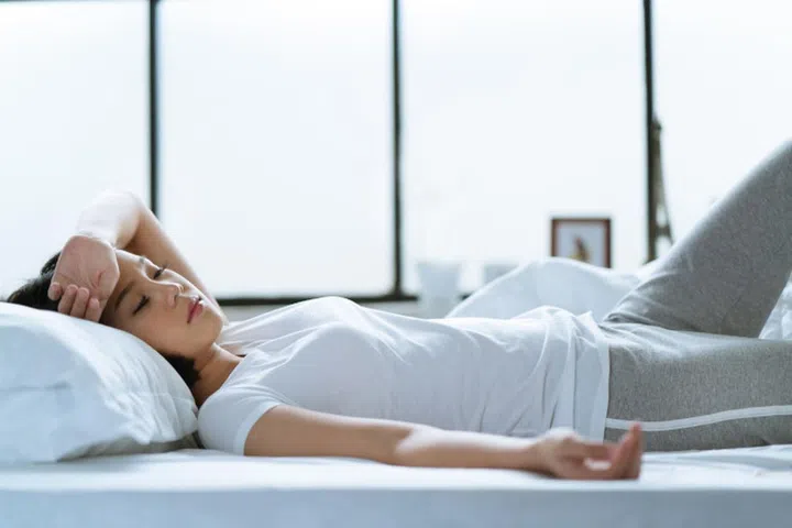 Asian girl is headache in bed.