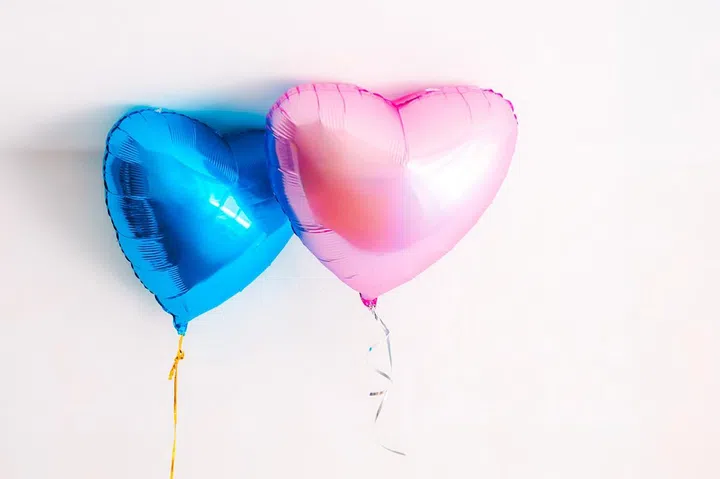 Pink and blue balloons on a white background, symbol of the Gender reveal party