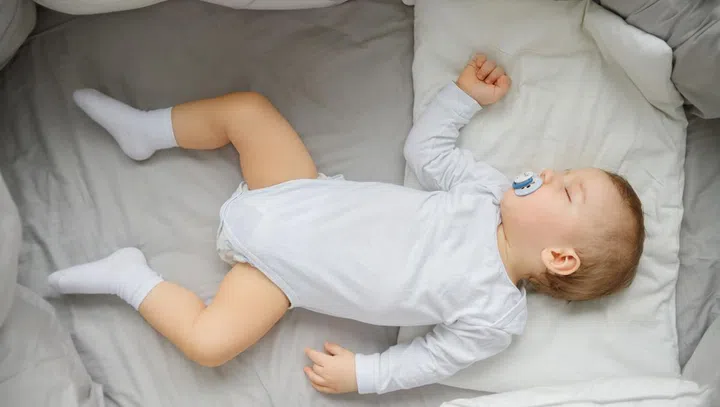 Little baby sleeping in crib , top view