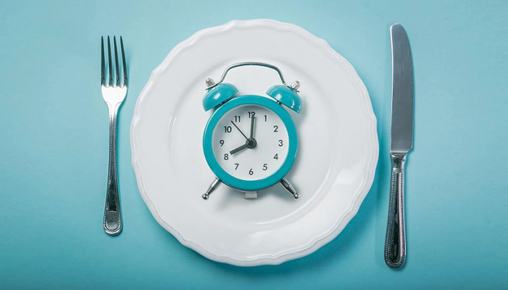 Intermittent fastin concept - empty plate on blue background, copy space