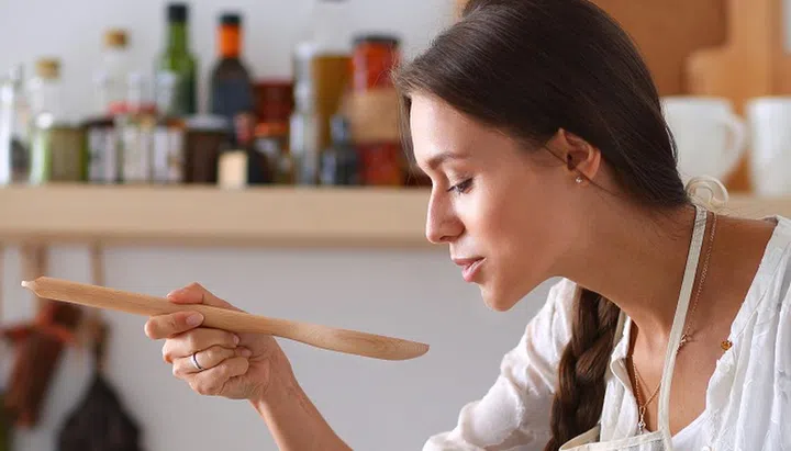 43777304 - cooking woman in kitchen with wooden spoon.