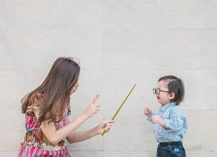 91937014 - closeup asian kid was scolded by his mother on blurred marble stone wall textured background with copy space