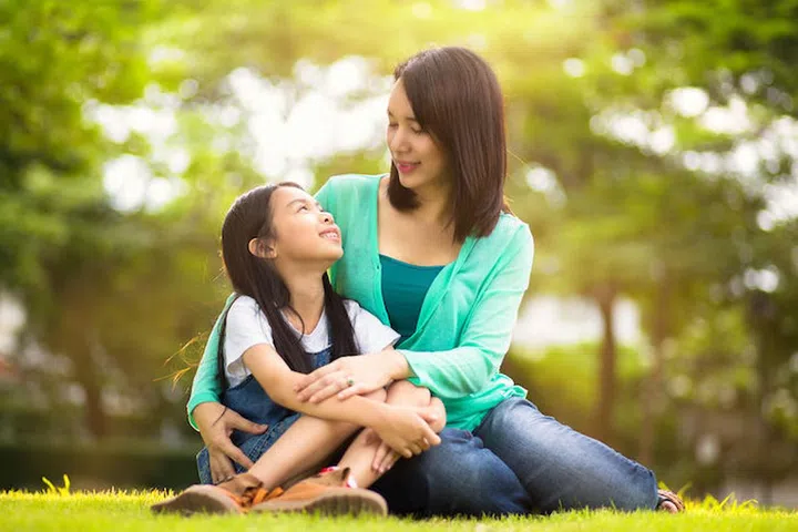 Happy young mother with her daughter at park