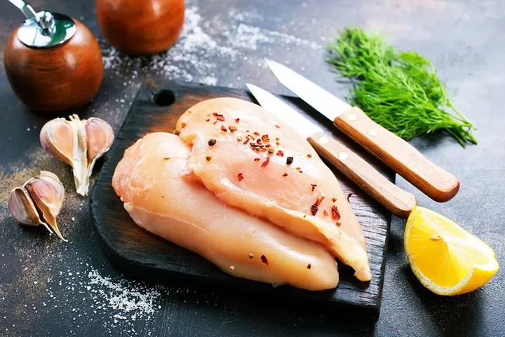 raw chicken fillets with spice on the plate