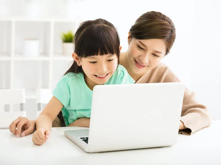 happy Little girl looking at laptop  with her mother