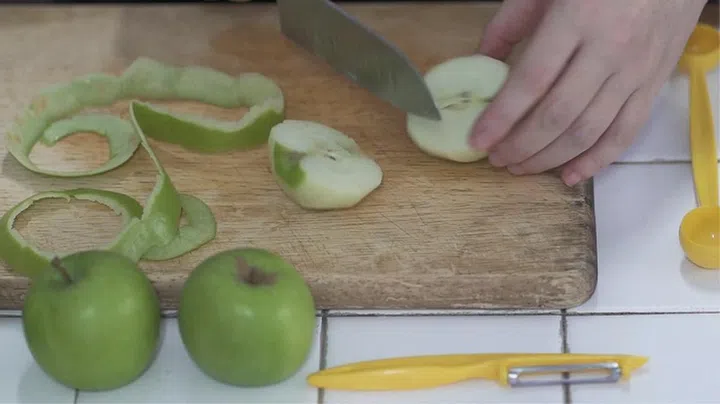 03. Peel apples, remove core and slide into thin slices. Add apple slices to a mixing bowl with the cinnamon powder, and sauce.