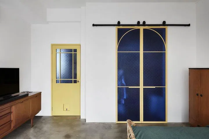 A barn door in the living room in a 2-bedroom walk-up apartment along East Coast Road.