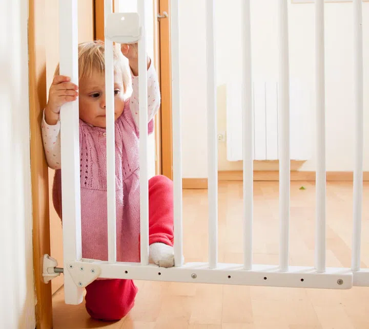 Small baby approaching opening gate of  stairs