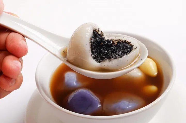 Tang Yuan(sweet dumplings) made from glutinous filled with black sesame in ginger syrup. Traditional cuisine for lantern festival, Mid-autumn festival, Dongzhi (winter solstice) and Chinese new year.