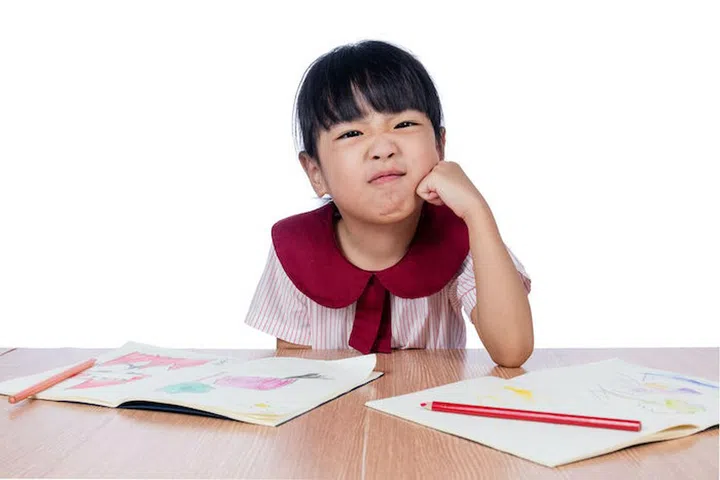 Asian Little Chinese girl drawing with color pencils in isolated white background