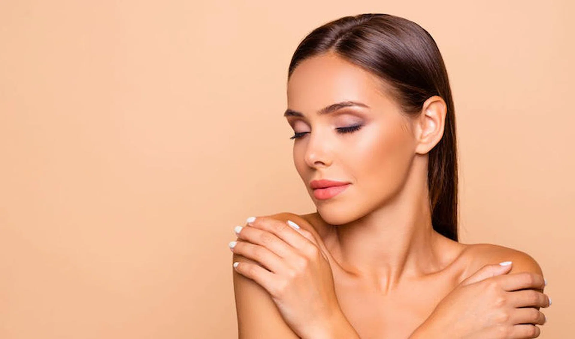 Close up picture of leisure lifestyle good-looking lovely charming pretty brown-haired lady hug her naked shoulders she close eyes isolated on pastel beige background with copy space for text