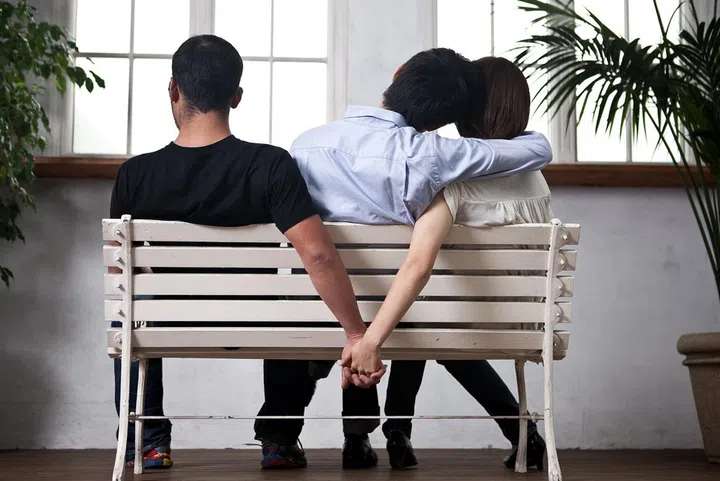 Young woman and man holding their hands behind the seat