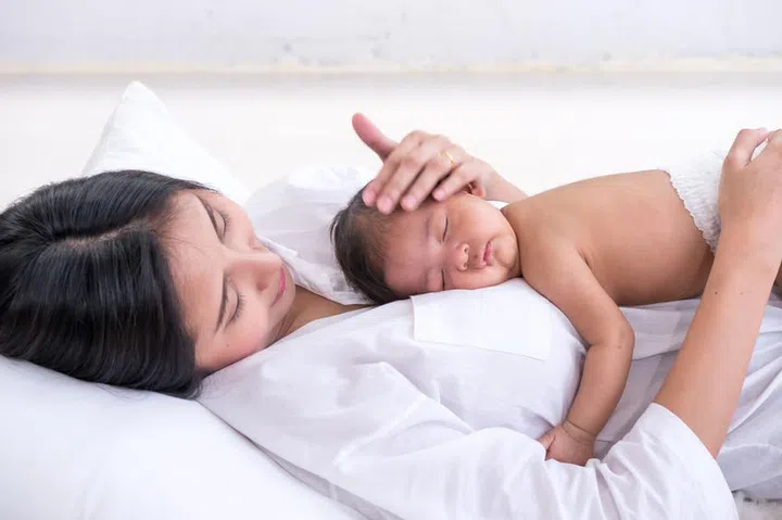 Sleeping newborn baby on mother's body