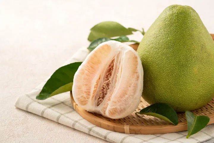 Fresh peeled pomelo with leaf on white table background for Mid-Autumn Festival fruit.