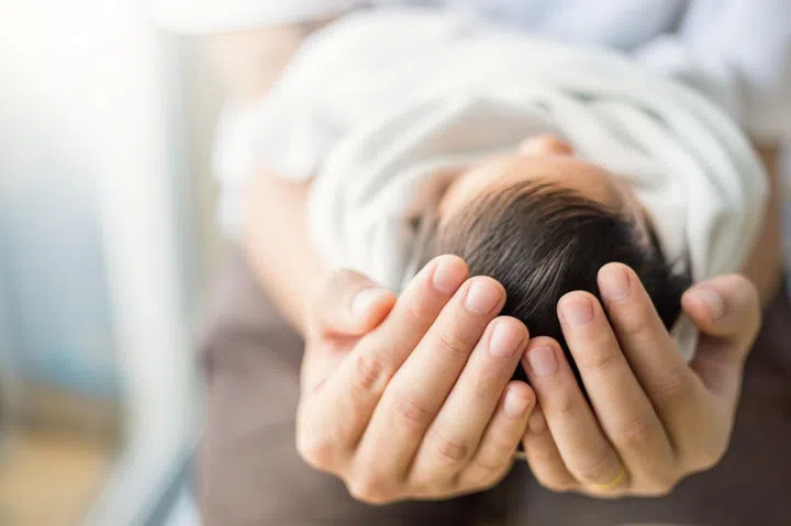 Close up father hands holding newborn baby, copy space background banner family concept