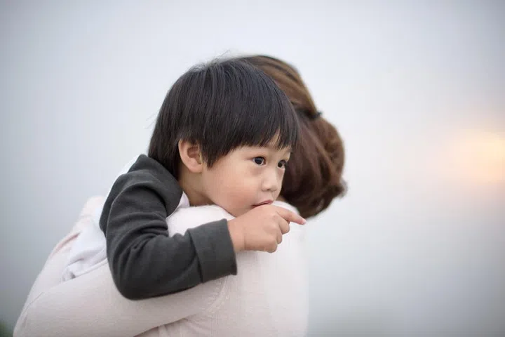 47109387 - mother hugging a little boy points his finger