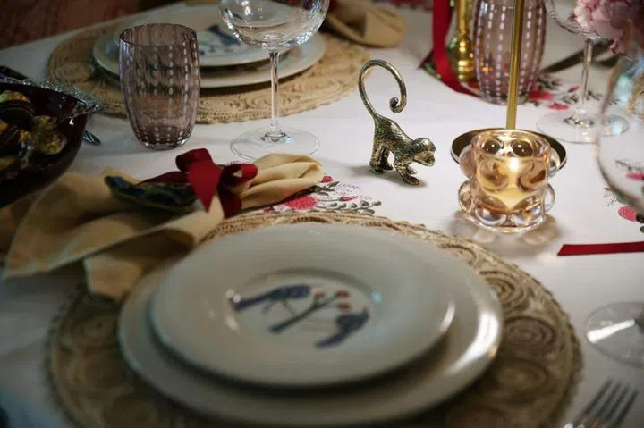 For Ms Juliane Bailey's 2023 Christmas table, the dominant colour is burgundy red, paired with muted pink that can be seen in elements such as brass monkeys with bows wrapped around their necks. ST PHOTO: JASON QUAH