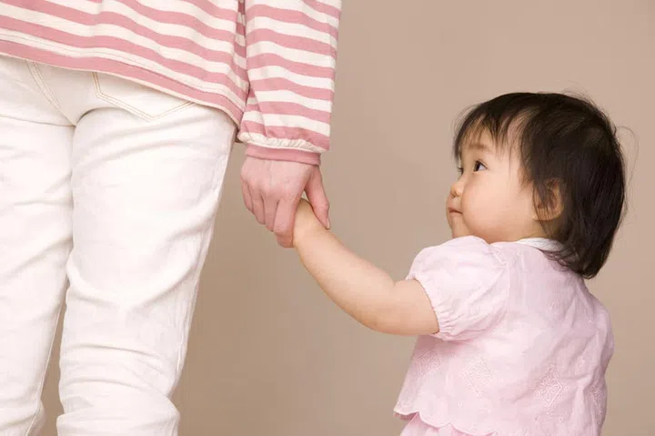 49293821 - baby walking by connecting the mother and hand