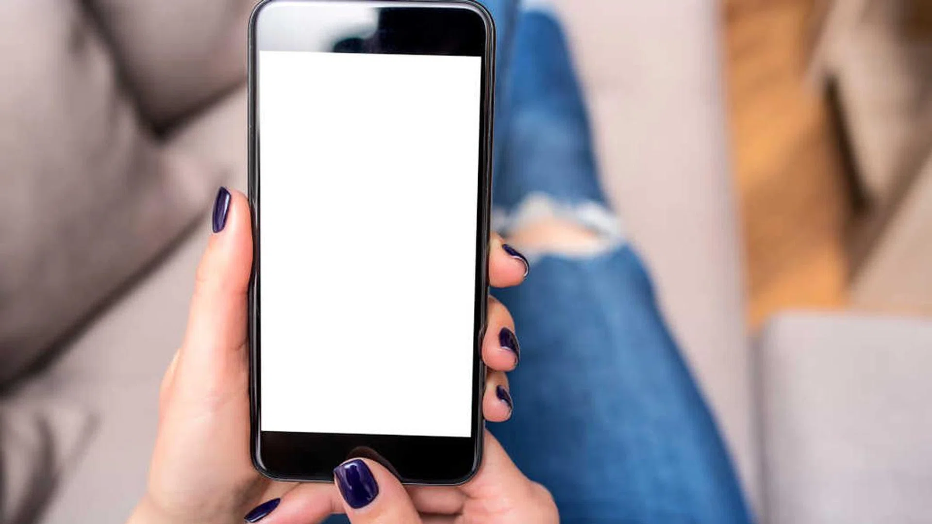 Woman using phone with copy space at home on the couch.